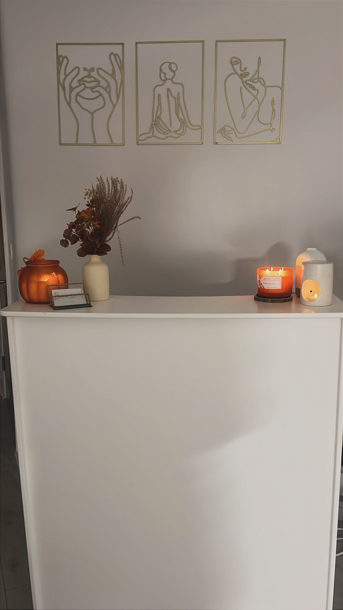 Warm candles and gold line artwork at the salon reception